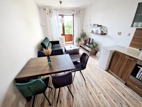 kuchnia i salon ze stołem i krzesłami w obiekcie Apartment Tatry Hiking & Wellness w Wielkiej Łomnicy