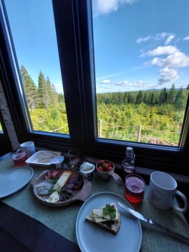 a table with plates of food in front of a window at ReindeerNook in Kuusamo
