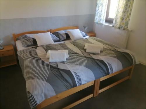 a bedroom with a large bed with two pillows at Chalupa Křenov 62 in Bernartice