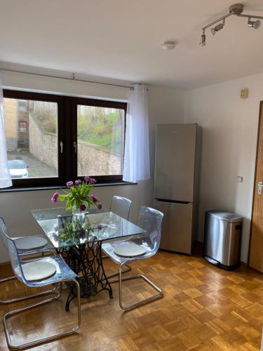 a kitchen with a glass table and chairs and a refrigerator at Ferienwohnung am Marktplatz in Weinheim