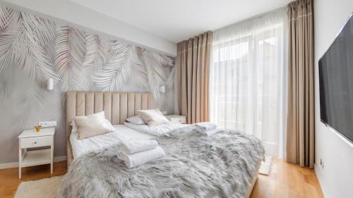 sypialnia z dużym łóżkiem i dużym oknem w obiekcie Apartamenty Sun & Snow Nadmorskie w mieście Sopot