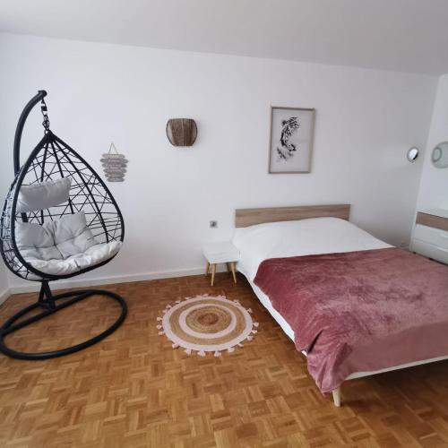 a bedroom with a bed and a hanging chair at Chambre cocooning tout confort Saint Marceau in Orléans