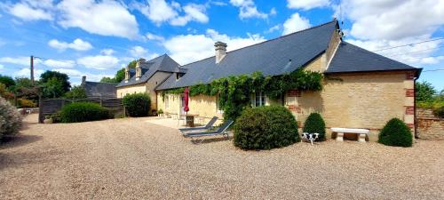 una casa con un banco delante de ella en Le domaine des Roseraies, en Monfréville