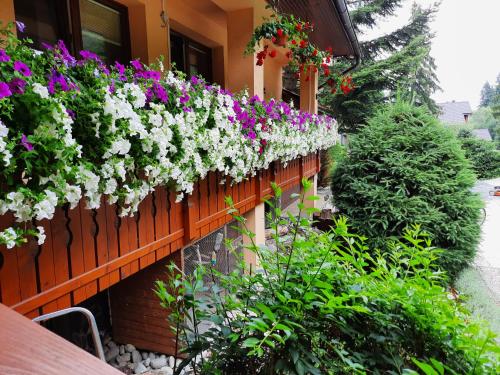 ogród z kwiatami na płocie w obiekcie Apartmány PACIFIC w Demianowskiej Dolinie