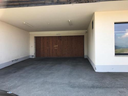 an empty garage with a wooden garage door at Résid. Les Esserts A42 in Champoussin