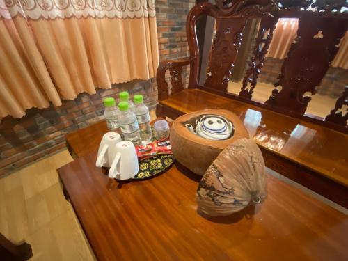 a table with a bowl of water and bottles on it at MAY Bungalow in Mui Ne