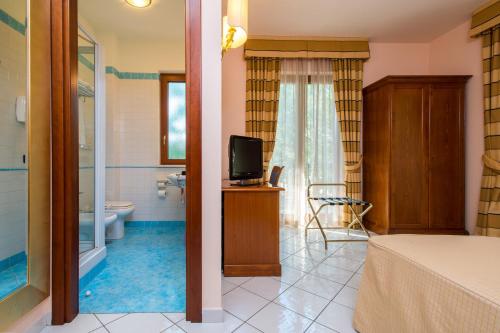 a bedroom with a bathroom with a toilet and a television at Hotel Villa Albani in Nocera Superiore