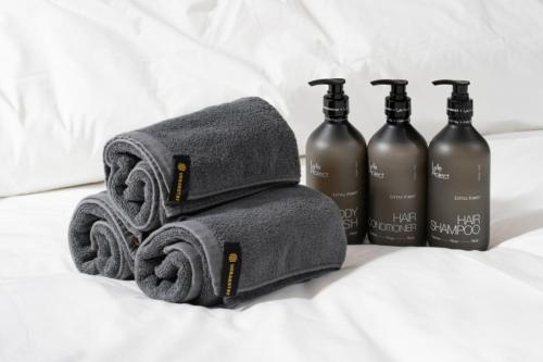 un gruppo di tre asciugamani e tre bottiglie di shampoo di Le Collective Yeosu a Yeosu