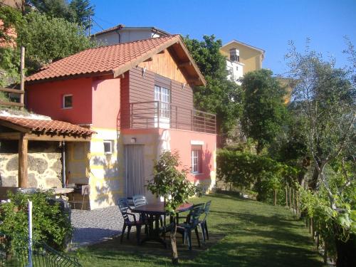 a house with a table and chairs in the yard at Chalé da Fonte - T2 in Geres