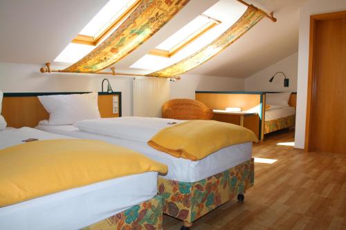 a bedroom with two beds and a table with a desk at Hotel Am Quellberg in Recklinghausen