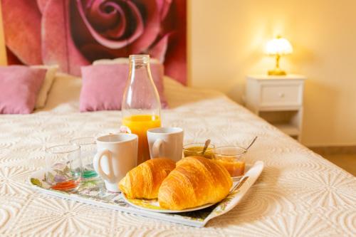 - un plateau de pain et de jus d'orange sur le lit dans l'établissement Chambres et Table d'Hôtes Les Trois Marquets, à Bourthes