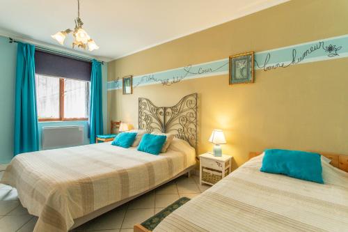 1 dormitorio con 2 camas y almohadas azules en Chambres et Table d'Hôtes Les Trois Marquets, en Bourthes