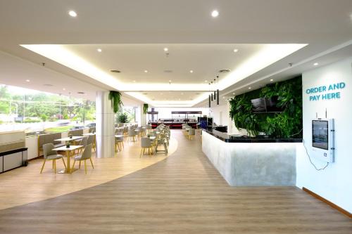 a restaurant with a bar and tables and chairs at Kuching Park Hotel in Kuching