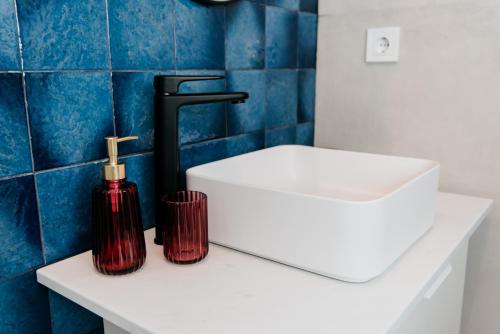 a bathroom with a white sink and a red bottle on a counter at Evo Residence Migdalului in Cluj-Napoca