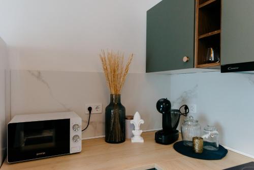 a kitchen counter with a microwave and a vase at Evo Residence Taietura Turcului in Cluj-Napoca