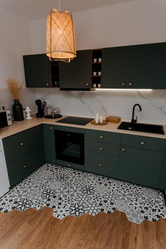 a kitchen with green cabinets and a black and white floor at Evo Residence Taietura Turcului in Cluj-Napoca