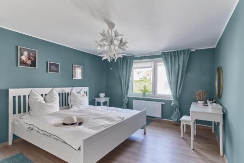 a bedroom with a white bed with a hat on it at Ferienhaus Lichtblick in Freital