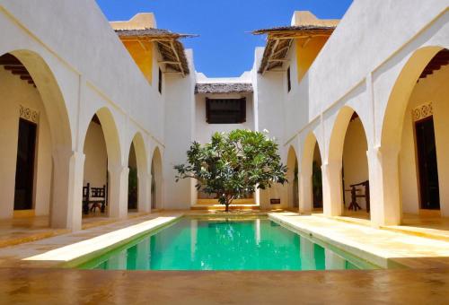 a courtyard with a pool in a building at Jahazi House in Lamu