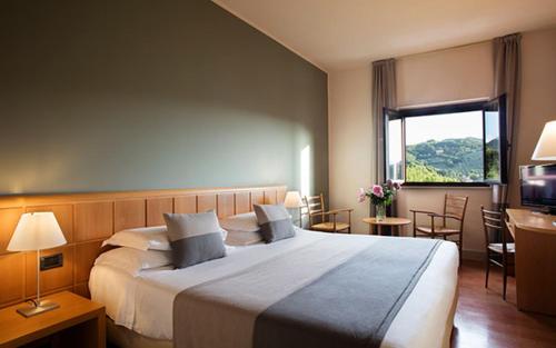 a hotel room with a large bed and a window at Hotel dei Duchi in Spoleto