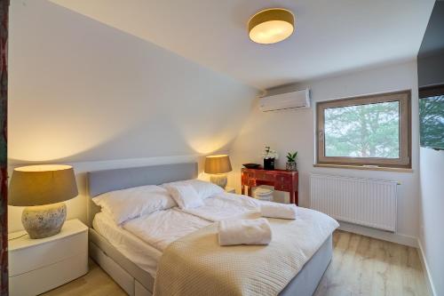 a bedroom with a bed and two lamps and a window at Znamirowickachata SAUNA JACUZZI SPA in Znamirowice