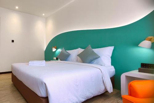 1 dormitorio con 1 cama grande y pared verde en Kuching Park Hotel, en Kuching