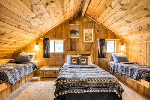 2 Betten in einem Zimmer mit Holzwänden in der Unterkunft Beaver Pond Chalet in Taos Ski Valley
