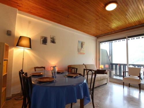 une salle à manger avec une table et des chaises bleues dans l'établissement Studio confort 4 pers. à Chantemerle, Serre-Chevalier – Balcon, parking, casier à ski - FR-1-330E-83, à Saint-Chaffrey