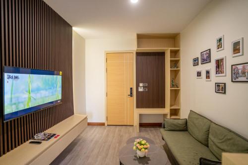 a living room with a couch and a flat screen tv at Hak Heng Hotel in Krong Poi Pet