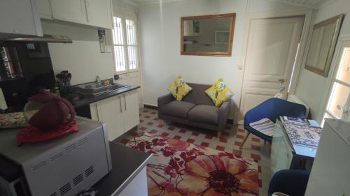 eine Küche mit Sofa und Waschbecken in einem Zimmer in der Unterkunft Vernet Jardin in Vernet-les-Bains