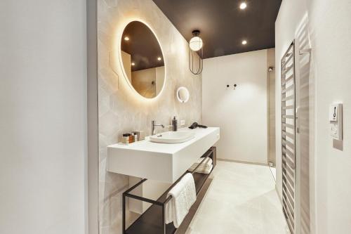 a bathroom with a sink and a mirror at HYPERION Hotel Salzburg in Salzburg