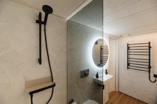 a bathroom with a shower and a sink and a mirror at Unique Tiny House at Saaremaa Golf & Country Club in Kuressaare