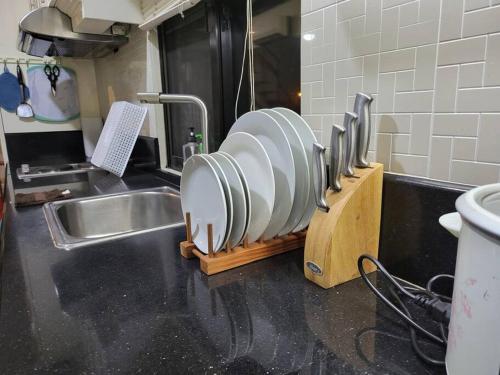 a kitchen counter with a sink and a row of dishes at Resort-type, spacious 1 bedroom condo in Kandi. in Angeles
