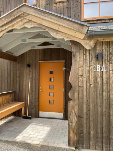 an entrance to a wooden building with an orange door at Funäsdalsporten Funäsdalen in Funäsdalen