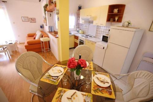 una cocina con mesa de comedor con rosas. en Apartments by the sea Ist - 19193 en Ist