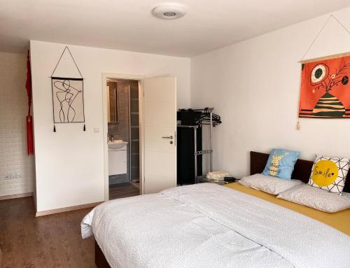 a bedroom with a bed and a refrigerator at Apartment CHEZ TONY in Strassen