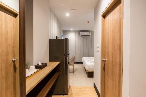 uma casa de banho com um frigorífico preto e um lavatório. em Hi Sotel - SHA Plus em Makkasan