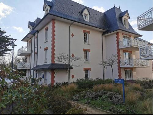 un grand bâtiment blanc avec un toit en gambrel dans l'établissement Magnifique vue mer - Tout confort, à Pléneuf-Val-André