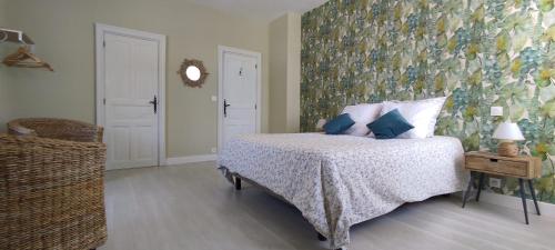 a bedroom with a bed with a floral wall at Domaine les Garrigues in Puygaillard-de-Quercy