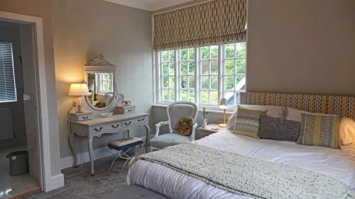 sypialnia z łóżkiem, biurkiem i lustrem w obiekcie Lauriston House w mieście Dartmouth