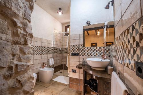 een badkamer met een wastafel, een toilet en een spiegel bij Il Rifugio dei Minatori in Iglesias