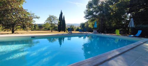 a large swimming pool with blue water at Domaine les Garrigues in Puygaillard-de-Quercy