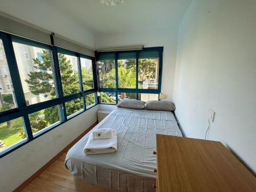 1 dormitorio con 1 cama, mesa y ventanas en Playa Dos Avenidas en Alicante