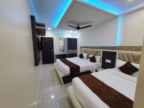 a hotel room with two beds and a blue ceiling at Kings Palace in Chennai