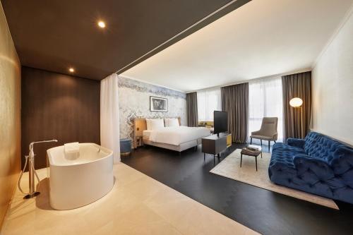 a hotel room with a bath tub and a bedroom at Hyperion Hotel Salzburg in Salzburg