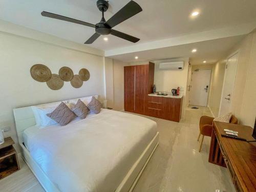 a bedroom with a white bed and a ceiling fan at Maui Palms in Korolevu