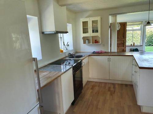 a kitchen with white cabinets and a stove top oven at Slotsgaardens hus in Jels