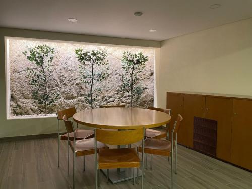a dining room with a table and chairs in front of a painting at Quinta da Menina Guest House in Vila Real