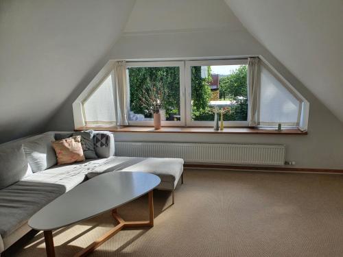 uma sala de estar com um sofá e uma janela em Slotsgaardens hus em Jels