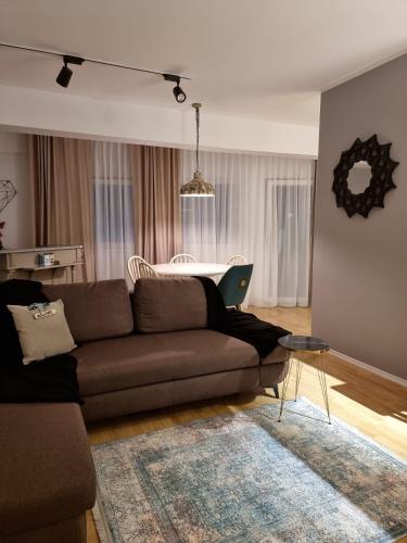 ein Wohnzimmer mit einem Sofa und einem Tisch mit einem Laptop in der Unterkunft AryaHome in Bistriţa