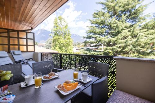 una mesa con 2 platos de comida en el balcón en Hotel Gartenresidence Zea Curtis, en Merano